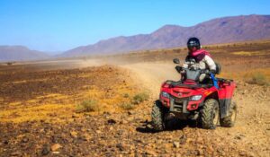 Ait Saoun, Morocco Man riding atv quad bike on sand in desert on a sunny day in Ait Saoun desert in Morocco