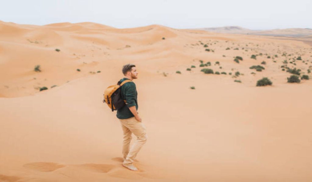 Man backpacker travel in Morocco, Sahara desert.